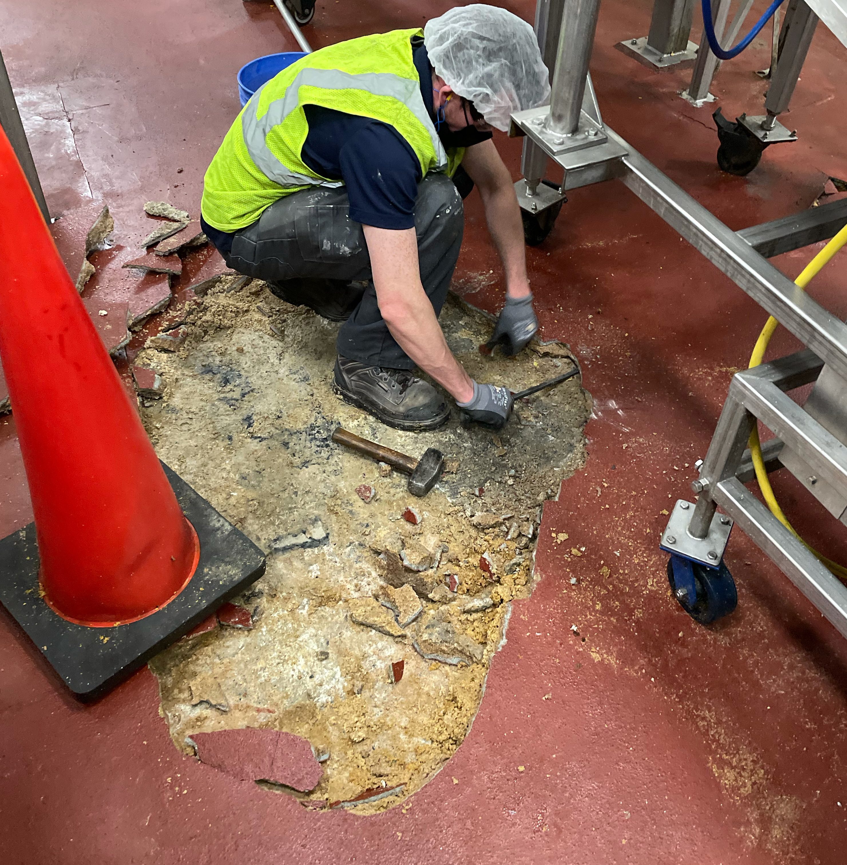 construction worker pulling up epoxy floor coating