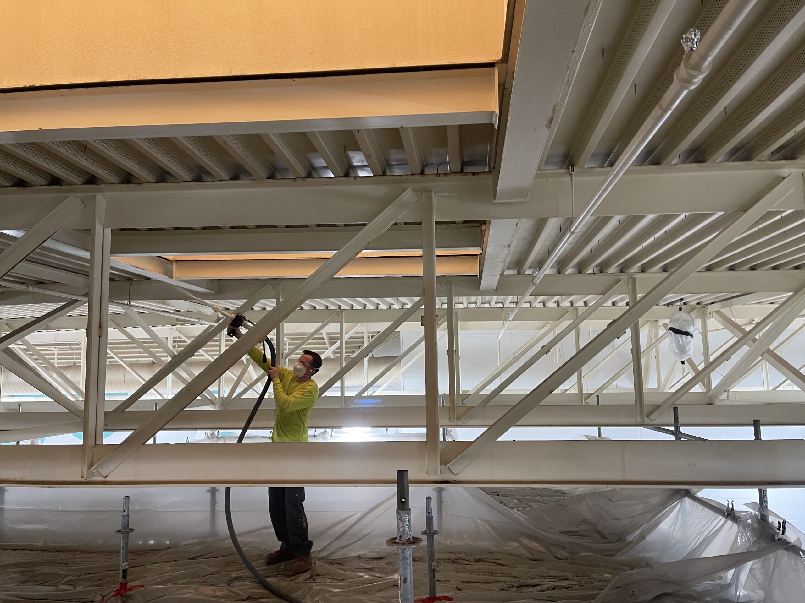 crew member painting ceiling structure