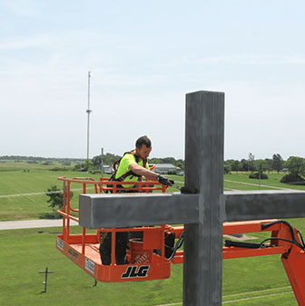 tyler on lift painting cross