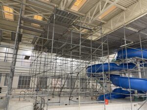scaffolding fully setup at indoor pool site with slide
