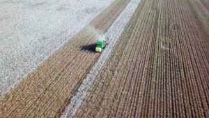 Aerial view of a Large green Cotton picker working in a field louisiana