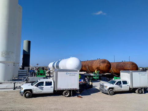 two blast it clean trucks in front of tanks for nationwide sandblasting and painting