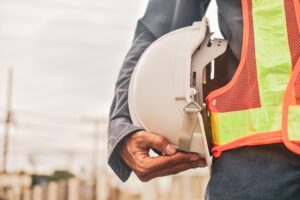 Technician holding white hat safety hard hat sunlight background in michigan