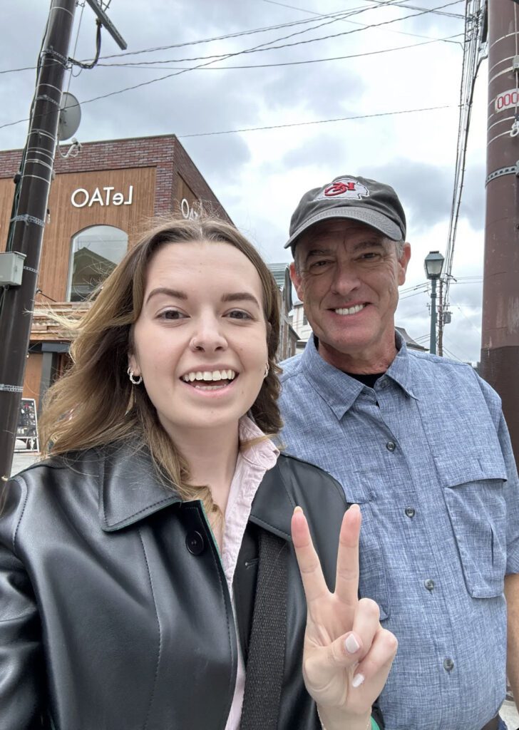 sarah holding up peace sign with her dad