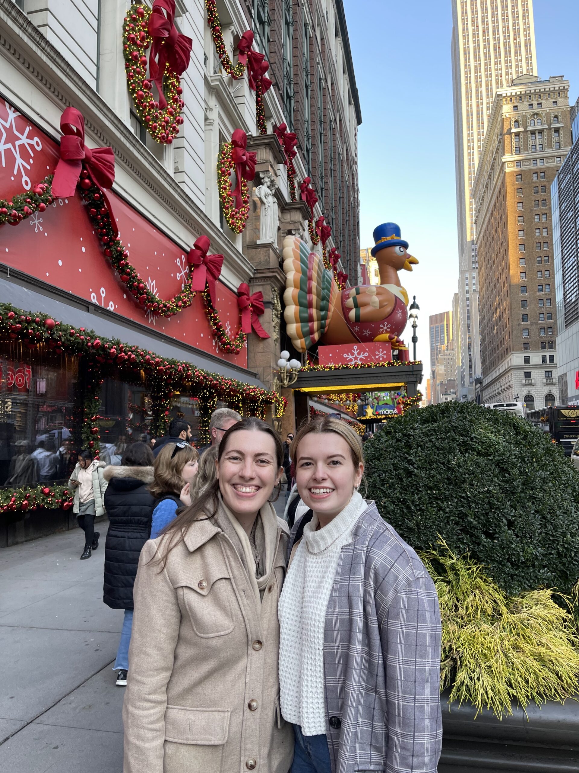 portrait of sarah and her sister outside in front of macy's thanksgiving display