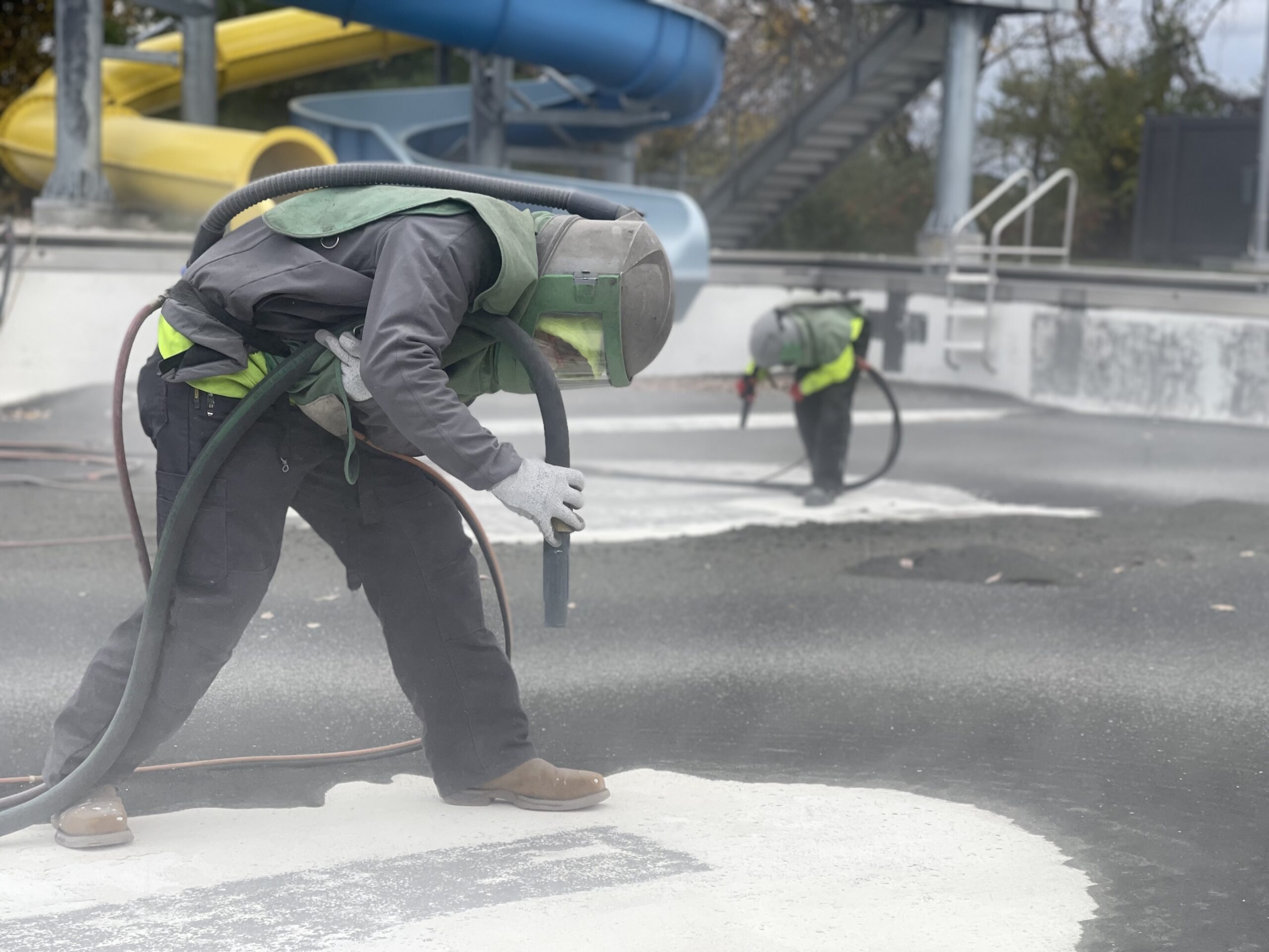 crew members sandblasting outdoor pool