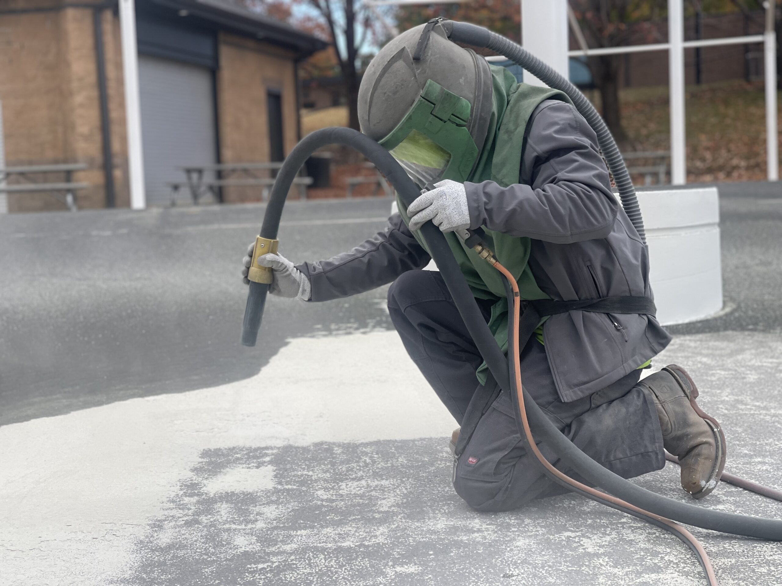 up close of crew member sandblasting pool