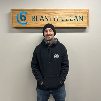 Portrait of daryl in front of blast it clean sign