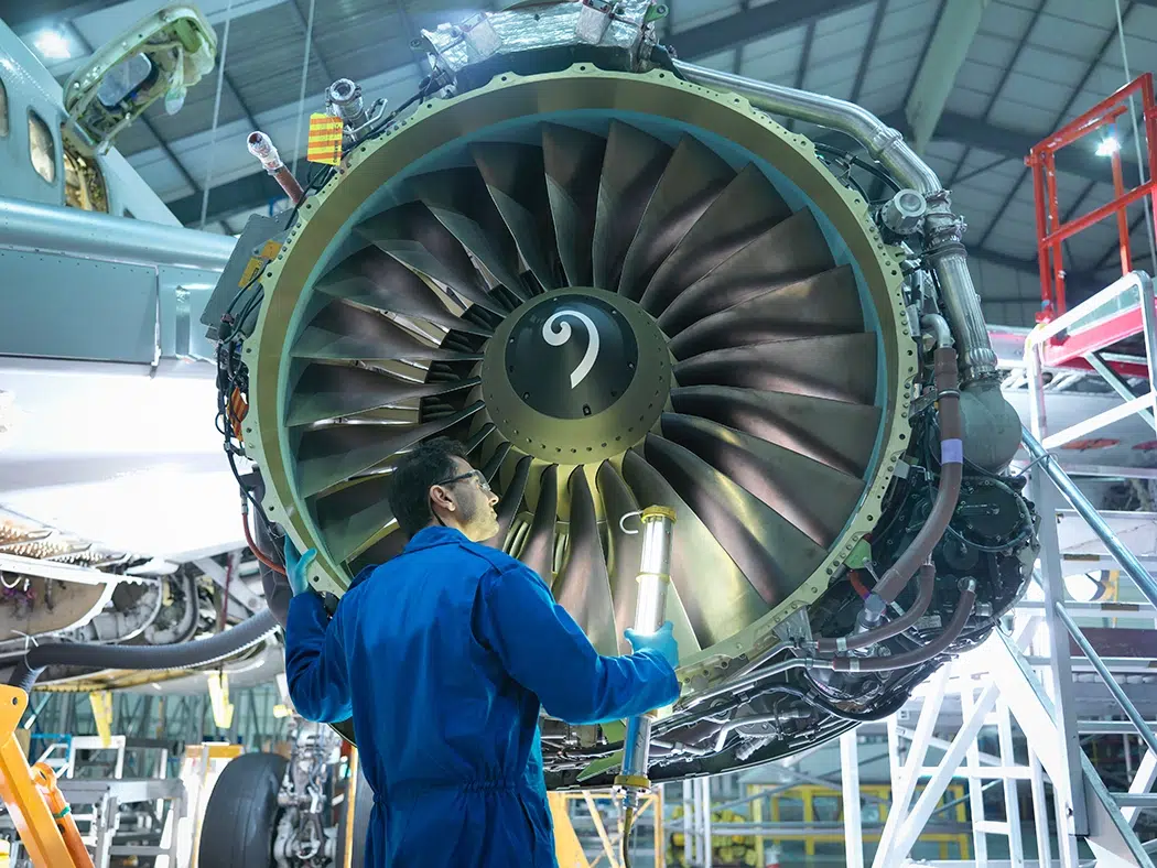 man inspecting aircraft engine man inspecting aircraft engine