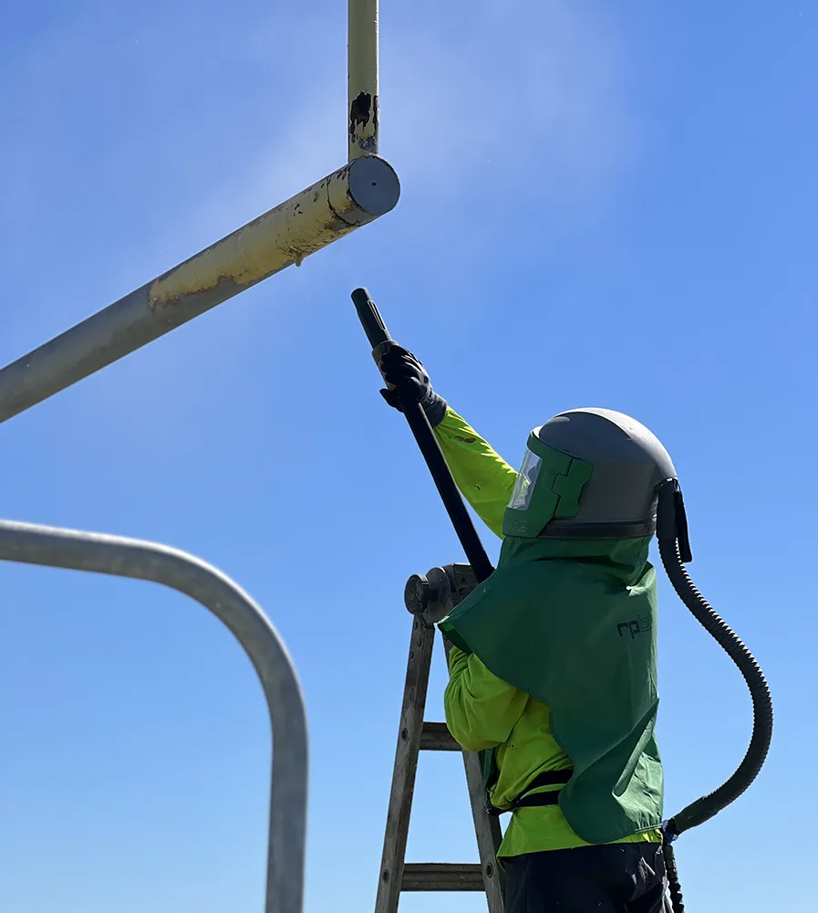 sandblasting the yellow coating off football goal post