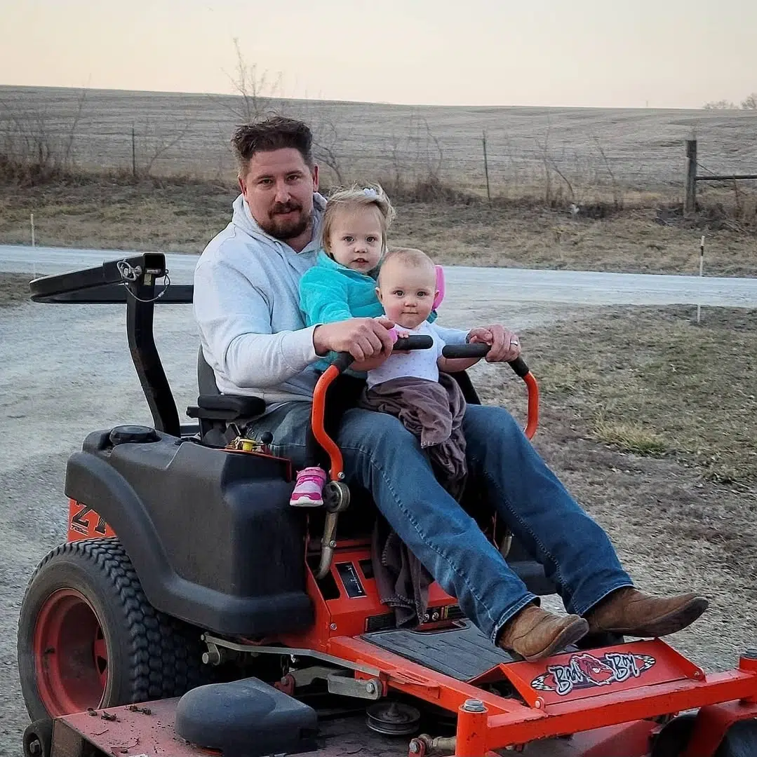 josh with two daughters on mower