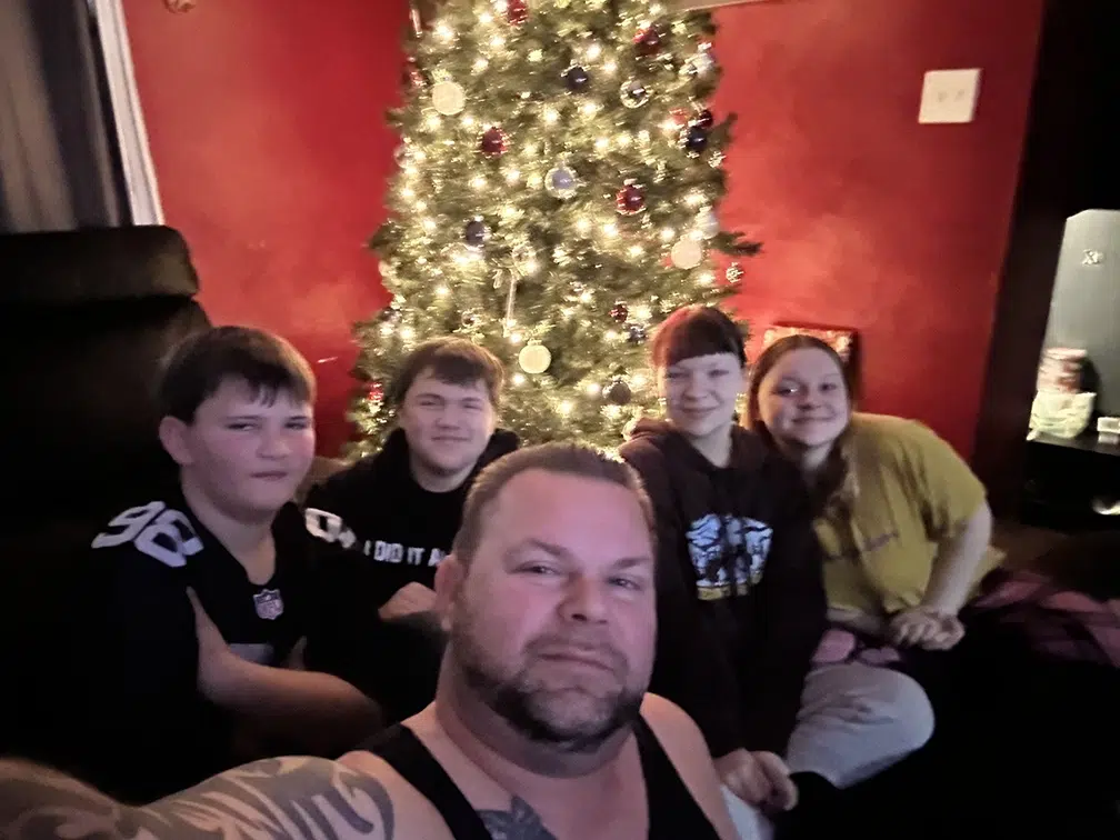 joe with family in front of christmas tree