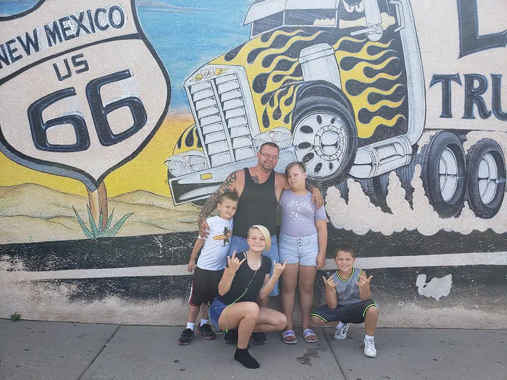 joe with family in front of mural