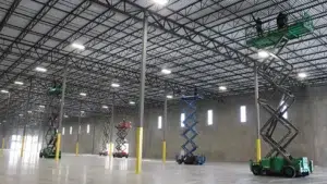 workers in scissor lifts inside warehouse