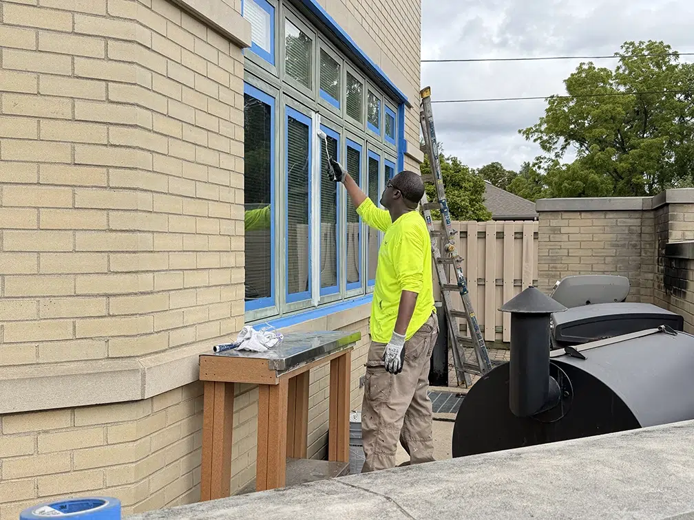 crew member painting outside of firehouse